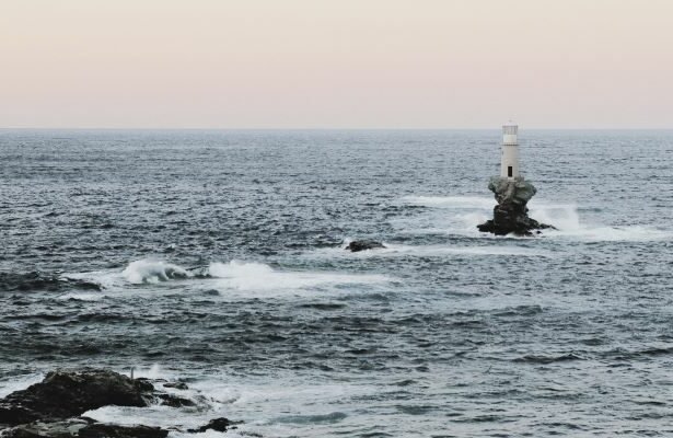 The impressive Tourlitis lighthouse located at the entrance of the port of Chora on the Greek island of Andros.